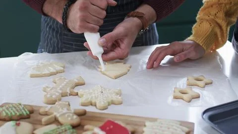 Parent is decorating tree-shaped sugar cookie in flat design style, food theme Stock Photos