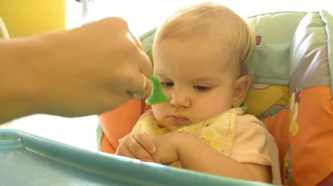 A parent feeding a small child Stock Footage 29674863
