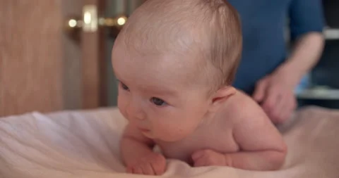 The parent gently taps the baby's back with his fingers. Stock Footage 145472546