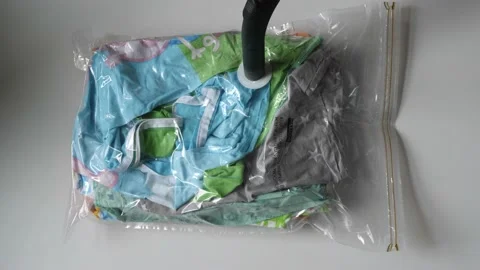 Parent getting air out of a vacuum bag, baby passing by Stock Footage 196696885