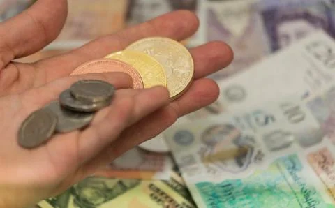 Parent Hand holding Bitcoin virtual money with his son holding regular coins Stock Photos