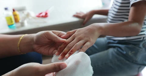 Parent helping her child perform first aid finger injury. Stock Footage 288849196
