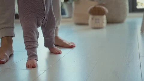 Parent Helps Baby Makes the First Steps Stock Footage 240726574