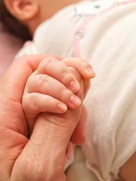 Parent holding an infants hand Stock Photos