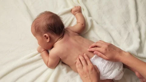 Parent lovingly caring for their baby's body, infant relaxing on comfortable Видео 291303536