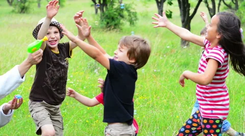 Parent playing with kids with a bubble blower Stock Footage