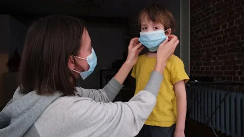 Parent puts on a protective mask on child 動画素材 148872465