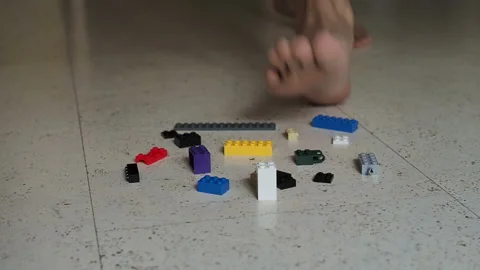 A parent steps on a children's constructor on the floor. Stock Footage 127499561