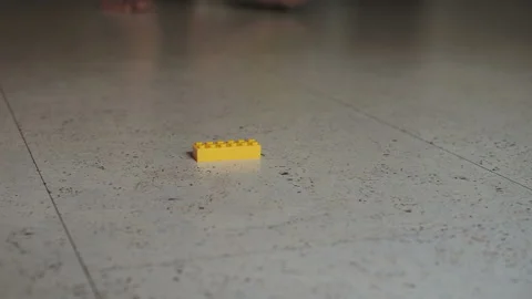 A parent steps on a children's constructor on the floor. Stock Footage 127499792