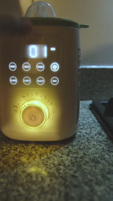 Parent using digital baby bottle warmer appliance Vídeo Stock 335184324