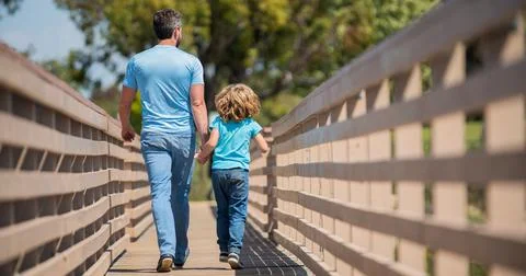 Parenting and fatherhood. fathers day. happy father and son walking outdoor back Stock Photos