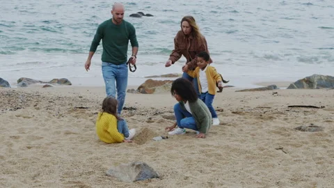 Parents and Children Construct Sand Castle On Beach Stock Footage 165264680