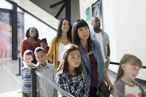 Parents and children waiting in queue at science center Stock Photos