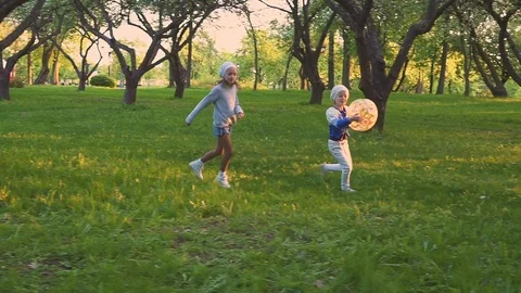 Parents and two daughters playing with ball in spring park in the blooming Video stock 98001688