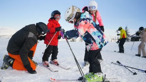 Parents are checking ski equipment of their children before the ride Stockbeeldmateriaal 112019872