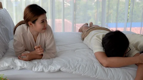 Parents are teasing their daughters on a bed in a house Stock Footage 127738188