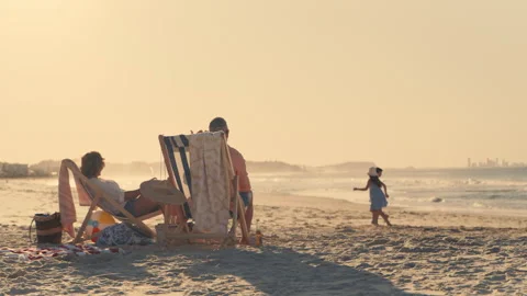 Parents at the beach looking after their children who are playing Stock Footage 262398662