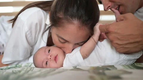 Parents caressing infant on bed Stock Footage 269353753