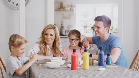 Parents With Children Sitting At Table Making Easter Decorations At Home Stock Footage 114308410