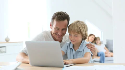 Parents with children using laptop computer at home Video stock 39636421