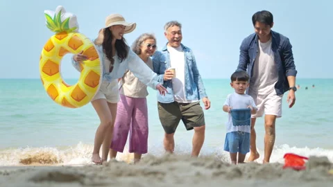 Parents crouching and playing with their young child using sand toys Video stock 338346600