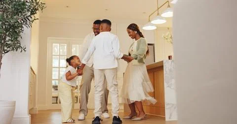 Parents, dancing and holding hands with children in kitchen, bonding or cel.. Stock Photos