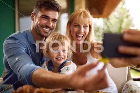 Parents with daughter taking selfie Stock Photos