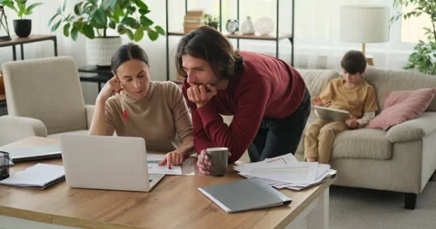 Parents discussing work and son using digital tablet at home Stock Footage 145227083