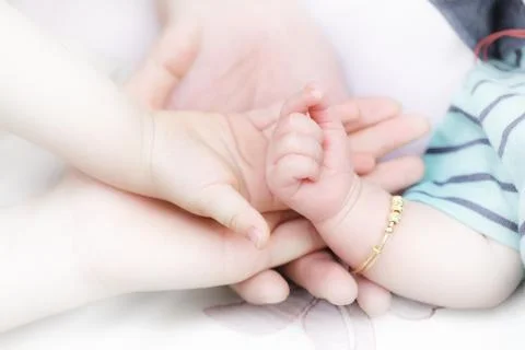 Parents dragging baby's hand Stock Photos