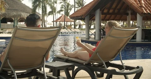 Parents with Drinks Poolside While Kids Jump Into Water, Tropical Resort Vidéo 112411685