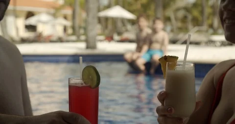 Parents with Drinks Poolside While Kids Jump Into Water, Tropical Resort Vidéo 112412495