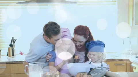 Parents guiding daughter adding eggs into bowl, bokeh overlay over family home Stock Footage 334000118
