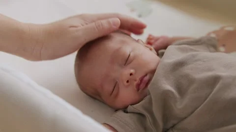 Parent's hand holding a thermometer to sleeping Stock Footage 336533551