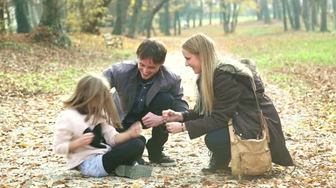 Parents having fun with daughter playing games in the park Stock Footage 59553797