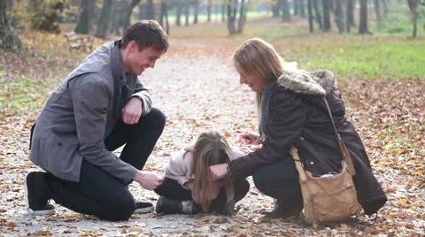 Parents having fun with daughter playing games in the park Stock Footage 59553804