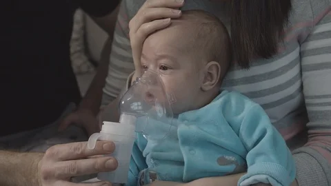 Parents Holding Mask Cold Little Child During Steam Inhalation Treatment At Home Vidéo 123763059