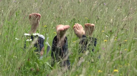 Parents lie down on spring grass,happy child playing on their back  Stock Footage 46208455