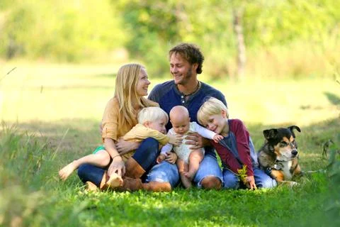 Parents Looking Lovingly at Each Other with Famil and Dog Stock Photos
