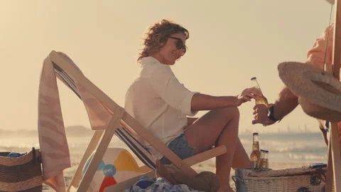 Parents making a toast at the beach with two bottles of beer Stock Footage 262397165