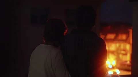 Parents suffering hugged while watching an ambulance near their home at night Stock Footage 132039097