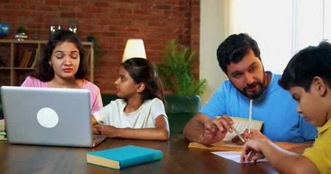 Parents teaching kids at home with books, laptop and paper Stock Footage 342486953