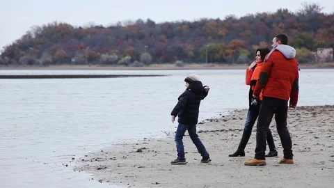 Parents with their young son throw stones into the lake Video stock 70797113