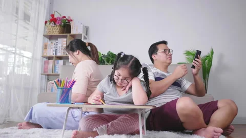Parents using phone and ignoring kid painting in the living room.  Video stock 172052341