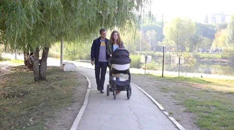 Parents walk with stroller Stock Footage 55865066