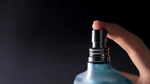 Parfume gets sprayed out of a blue bottle/ side view / 40% Slow-motion Stock Footage 122041701