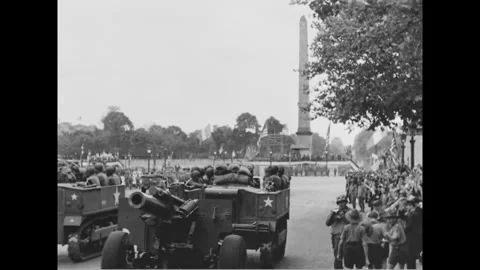 PARIS - 1944: Artillery column - Half-tracks and guns pass a flag-lined obelisk Stock-Footage 344005839