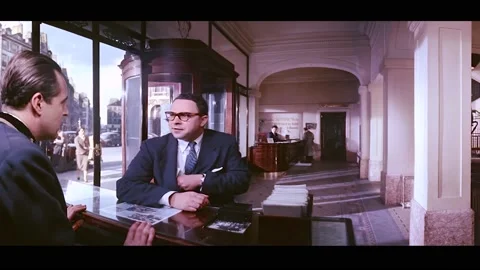 PARIS - 1955 - A man asks a concierge in a Paris hotel about his friends who are Stock Footage 337882656