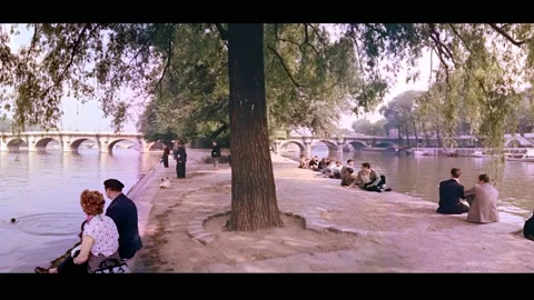 PARIS - 1955 - A man throws something in the Seine for his dog to retrieve. Vídeos de archivo 328166623
