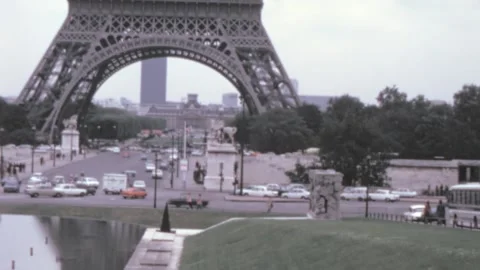 Paris - 1975: vehicles in traffic by Eiffel tower landmark in city center Stock Footage 220938542