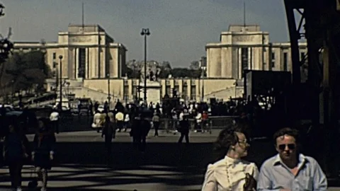 Paris 1980: people walk under the Eiffel Tower Stock Footage